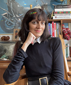 Headshot of DJ Jauretsi looking directly at the camera and resting their face on their palm.