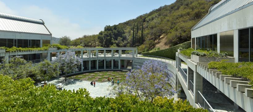 Image of Taper courtyard with visitors looking at the lily pond and mountains in the background