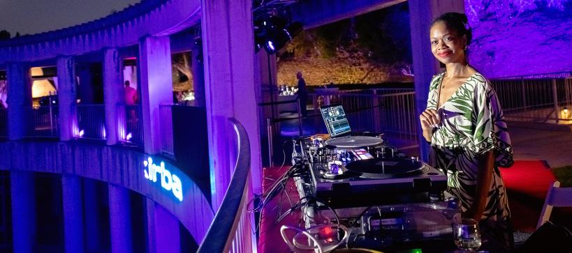 A DJ smiles for the camera at her turntable.