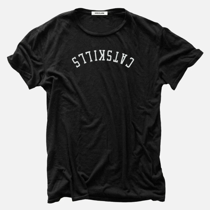 White letters spelling "CATSKILLS" appears upside down on a black t-shirt