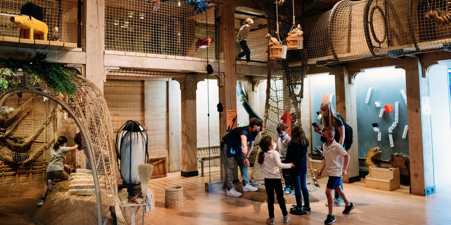 A phot of children playing inside Noah's Ark at the Skirball in the climbing ropes section of the exhibition.