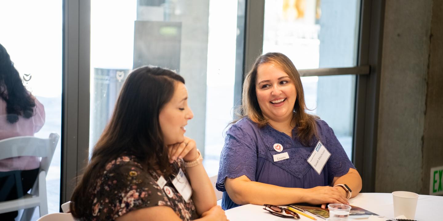 Two teachers sitting at a table at a workshop.