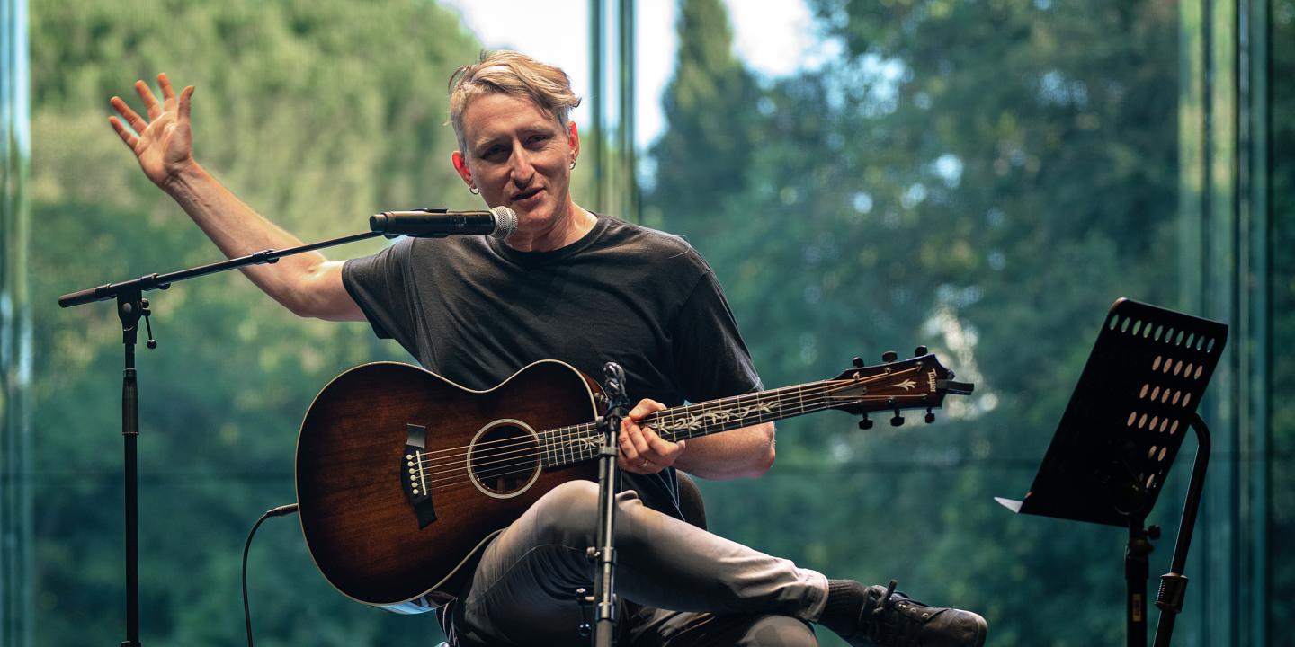 Shane Parish performing on stage with acoustic guitar