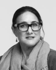 Nancy Keystone black and white photo wearing thick-rimmed glasses and a scarf.