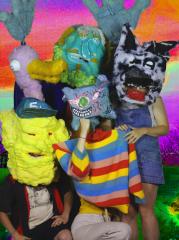 Four actors with giant colorful puppet masks on.