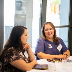 Two teachers sitting at a table at a workshop.