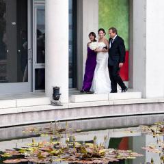 A bride walks next to a Lilly pond with parents