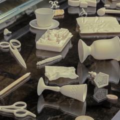 An assortment of white objects including scissors and cups are laid across a black table.