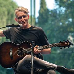 Shane Parish performing on stage with acoustic guitar